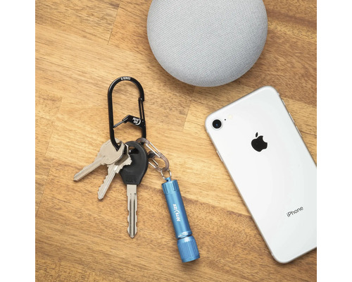 Schlüsselanhänger mit Schlüssel, Taschenlampe, Smartphone und Lautsprecher auf Holztisch