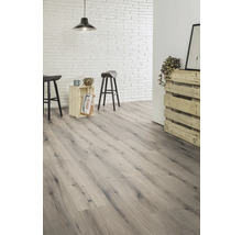 Heller Raum mit Laminatboden in Holzoptik, Backsteinwand und Barhockern