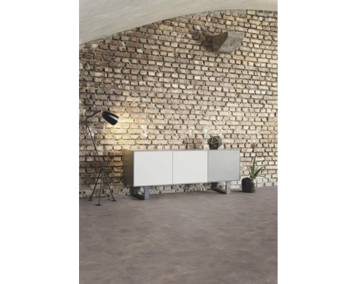 Innenraum mit Sideboard, Stehlampe und Ziegelwand für eine moderne Wohnraumgestaltung.