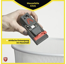 Eine Hand hält eine Mausefalle über einen Mülleimer zur einfachen Entsorgung.