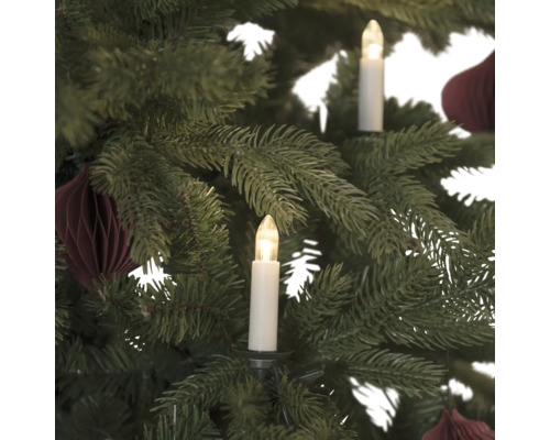 Detailaufnahme eines Weihnachtsbaums mit Baumkerzen und Baumschmuck