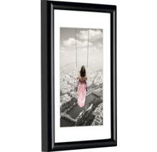 Gerahmtes Bild mit einer Frau auf einer Schaukel über einer Stadt
