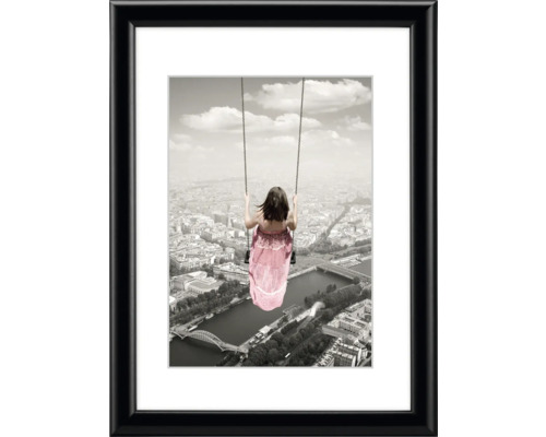 Gerahmtes Bild mit einer Frau auf einer Schaukel über einer Stadt