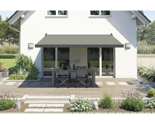 Terrasse mit Markise und Gartenmöbeln vor einem Haus