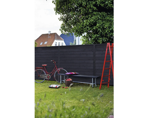 Szene im Garten mit Holzzaun, Bank, Leiter und Fahrrad
