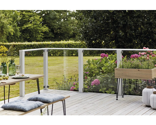 Terrasse mit Glasgeländer, Holzboden, Tisch und Bänken im Garten.