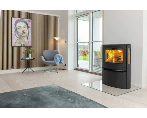 Wohnzimmer mit Kaminofen, Sessel und dekorativer Wand
