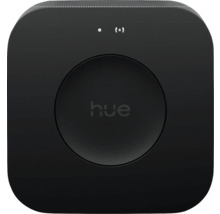 Philips Hue Bridge Smart Home Zentrale in Schwarz, quadratisch mit abgerundeten Ecken und zentraler Taste mit Philips Hue Logo.