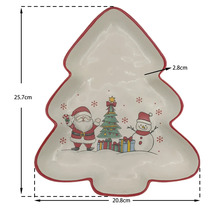 Servierplatte in Tannenbaumform mit Weihnachtsmotiven, 25,7 Zentimeter hoch, 20,8 Zentimeter breit und 2,8 Zentimeter tief.