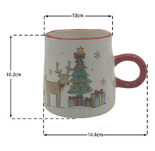 Weihnachtstasse aus Keramik mit Rentier- und Tannenbaum-Motiv, Höhe 10,2 Zentimeter, Breite 14,4 Zentimeter, Durchmesser 10 Zentimeter.